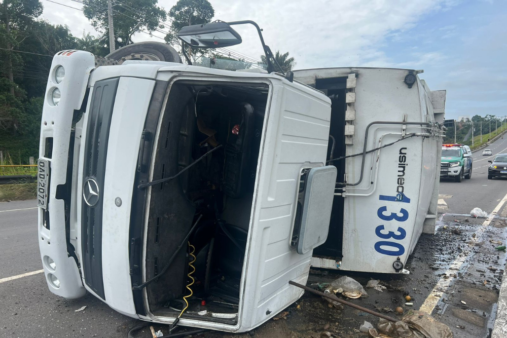 Caminhão de lixo tomba na avenida das Flores e deixa motorista ferido Caminhão de lixo tomba na avenida das Flores e deixa motorista ferido